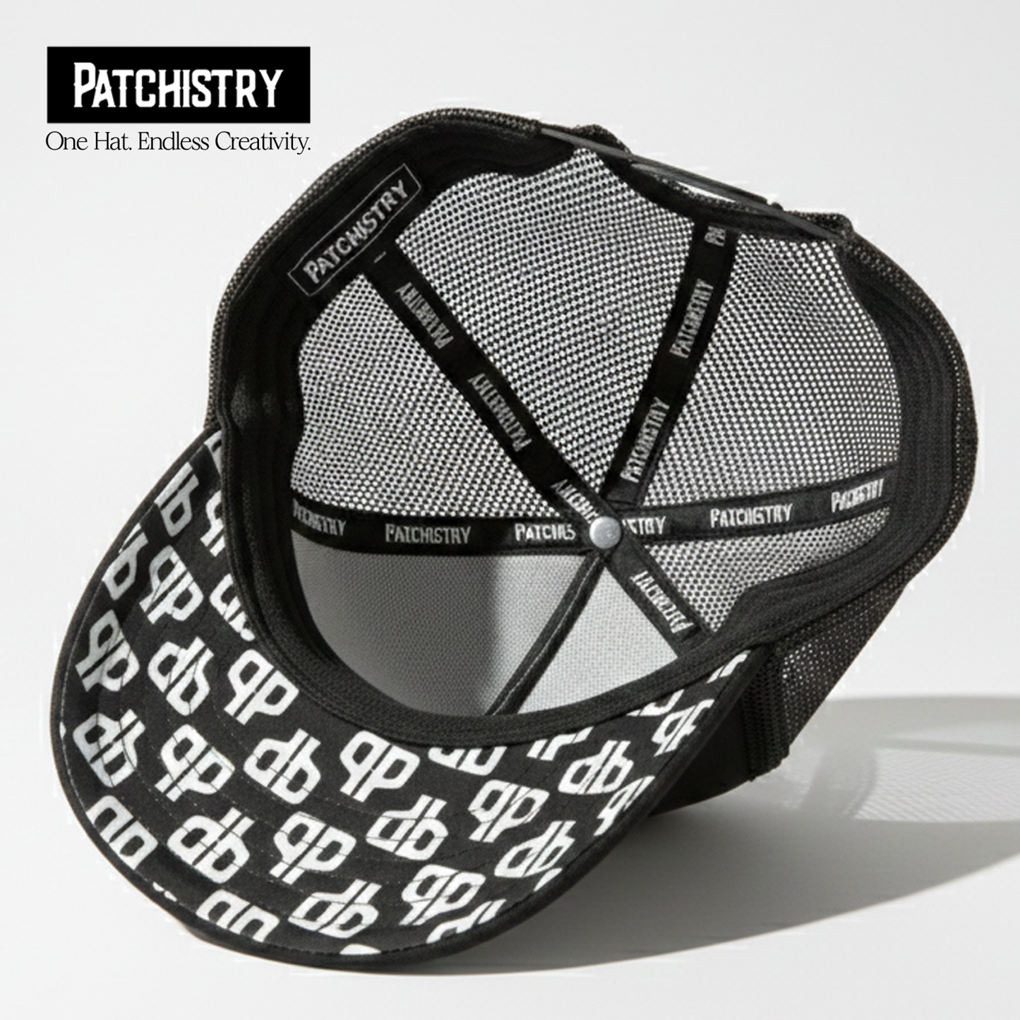 Black trucker hat under-brim patch detail — patches attach to the brim too