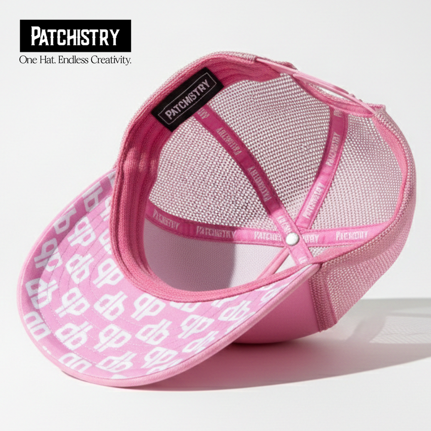 Pink trucker hat under-brim patch detail — patches attach to the brim too